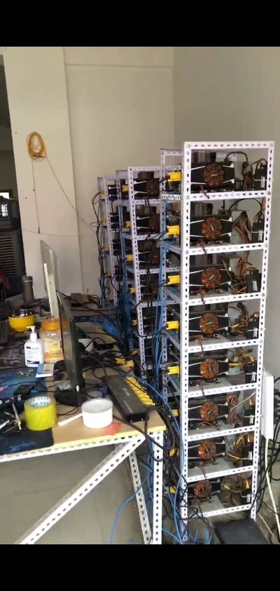 A sprawling mining farm bathed in ambient lighting showing rows of mining rigs